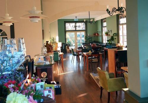 une salle avec des tables et des chaises dans un restaurant dans l'établissement Hotel De Gravin van Vorden, à Vorden