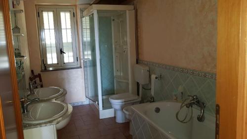 a bathroom with two sinks and a tub and a toilet at Costa di Mare in Monasterace