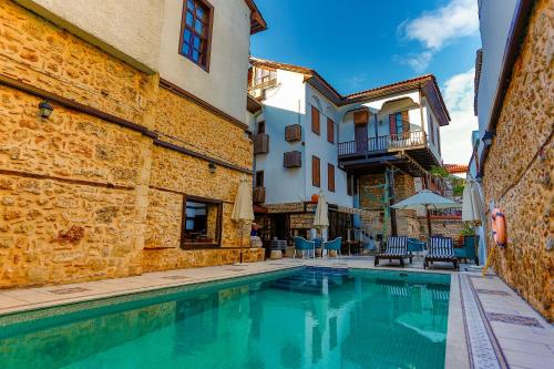 a swimming pool in a building with chairs and umbrellas at Atelya Art Hotel in Antalya