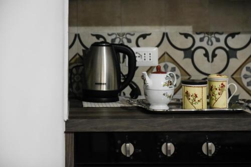 a counter with a tea kettle and cups on it at Giardino Dei Limoni Apartment in Oliena