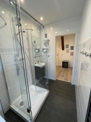 a bathroom with a shower and a sink at Hof Steinhütten Schlafstrandkorb in Westerhever