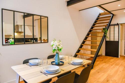 une salle à manger avec une table et des chaises et un escalier dans l'établissement Le Duplex - Terrasse au cœur de Marseille Panier, à Marseille
