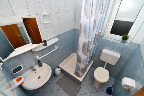 a bathroom with a sink and a toilet and a shower at apartmani Novotny- žuti in Rab