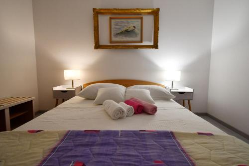 a bedroom with a bed with towels on it at apartmani Novotny- žuti in Rab