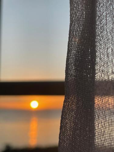 a close up of a curtain with the sunset in the background at Douceur Marine in Cancale