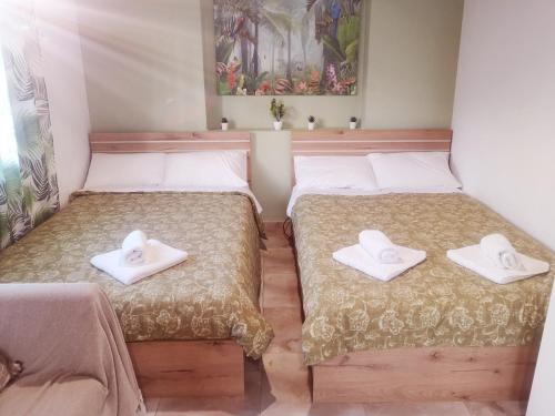 a room with two beds with towels on them at City Hall House in Volos