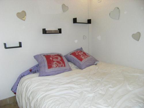 - une chambre dotée d'un lit avec des cœurs sur le mur dans l'établissement Appartement Cap d'adge à côté camp natu, au Cap d'Agde