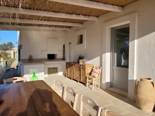 an outdoor patio with a wooden table and chairs at Masseria Ferarelli Trepizzi in Diso