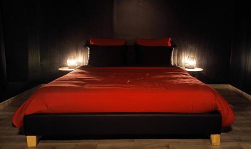 - une chambre avec un lit rouge et deux lampes dans l'établissement Le BLACK DIAMOND, à Incheville