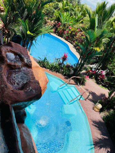 a swimming pool with a water slide in a resort at Aunty Arenal Lodge in Fortuna