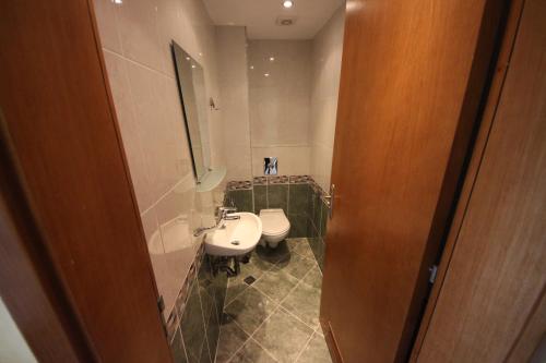 a bathroom with a white sink and a toilet at Menada Midia Apartments in Sunny Beach