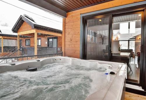a large bath tub in a room with a balcony at 05 Chemin des Cascades in Stoneham