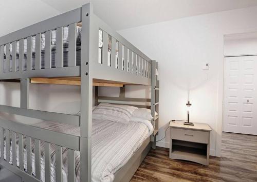 a white bedroom with a bunk bed and a desk at 05 Chemin des Cascades in Stoneham