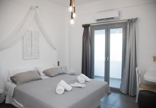 a bedroom with a bed with white towels on it at Eunoia Apartments in Fira