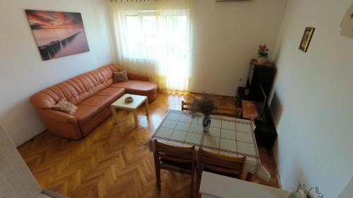 - un salon avec un canapé et une table dans l'établissement Apartments Juraga, à Murter