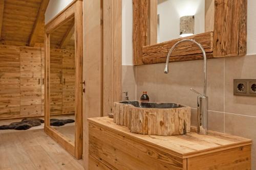 un bagno con lavandino in legno in una baita di tronchi di iFlat Chalet Carole Ortisei a Ortisei