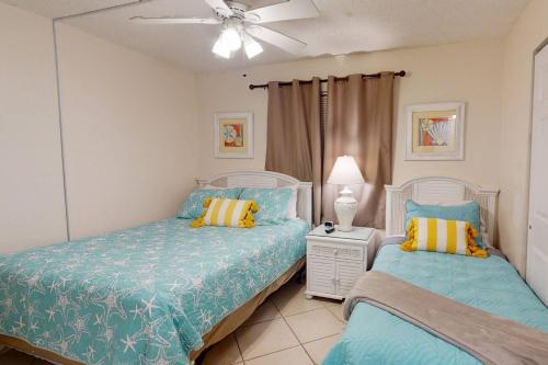 una camera con 2 letti e un ventilatore a soffitto di 206 - Sandy Shores a St Pete Beach