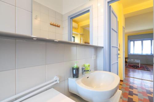 een badkamer met een witte wastafel en een spiegel bij PrimoPiano - Ponzio in Milaan