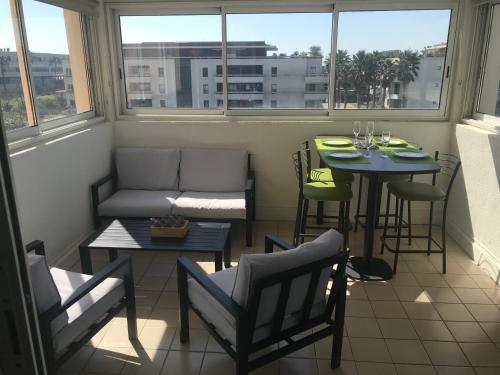 d'un balcon avec une table, des chaises et un canapé. dans l'établissement Charmant T2 Les Plages Dorées vue mer + parking, à Sète