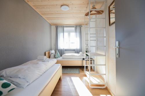 um pequeno quarto com uma cama e uma janela em WOHNUNG OBERGESCHOSS mit 3 Schlafzimmer in ruhiger Gegend em Mäder