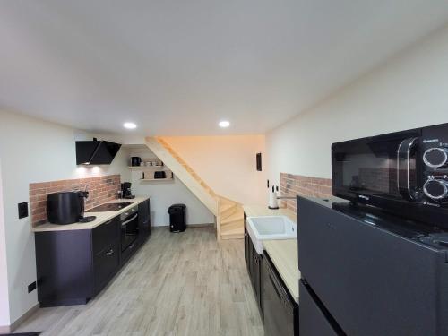 a kitchen with a staircase in the background at Maison de caractère in Crancey