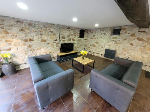 un salon avec deux canapés et une télévision dans l'établissement Maison de caractère, à Crancey