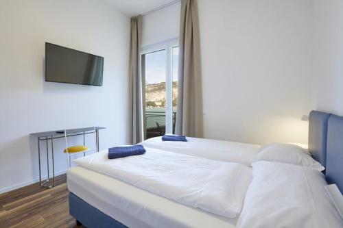 a bedroom with a large bed with a television on the wall at Hotel Paradiso Conca d'Oro in Nago-Torbole