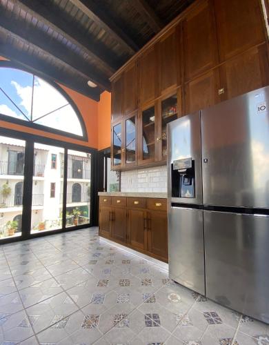 a kitchen with a stainless steel refrigerator and wooden cabinets at Castillo De La Santa Cruz in Guanajuato