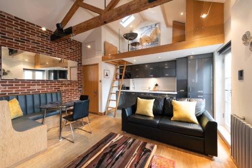 a living room with a black leather couch and a table at My Unique Place - St Peters Mews in St. Albans