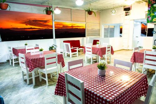 a restaurant with red and white tables and chairs at Hotel Boutique Papagayo in Tarapoto