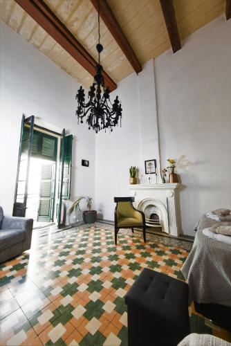 a living room with a chandelier and a fireplace at Grand House of Character Valletta in Il-Furjana