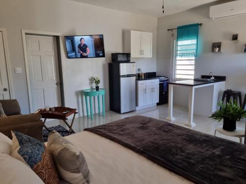 a living room with a kitchen with a refrigerator and a table at Bel Ti Plas in The Valley