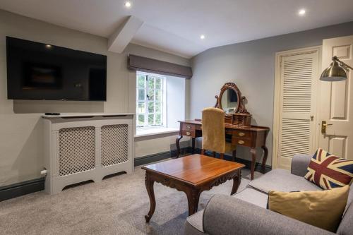 a living room with a couch and a table and a desk at Boscundle Manor in St Austell