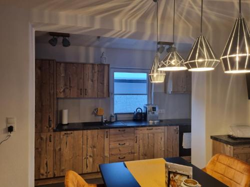 una cucina con armadi in legno e lampadari pendenti di Haus Schönblick a Neustift im Stubaital