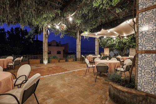 a restaurant with tables and chairs in a patio at Aequa Hotel in Vico Equense
