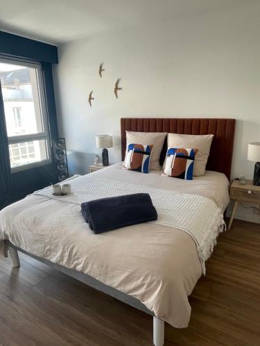 a bedroom with a large bed with two pillows on it at Appartement Entre Paris et Disney in Ozoir-la-Ferrière