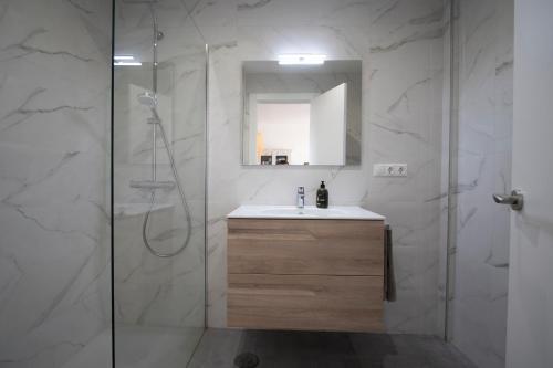 ein Bad mit einem Waschbecken und einer Glasdusche in der Unterkunft Apartamento en primera línea de playa in Tarifa