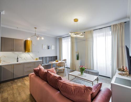 a living room with a couch and a kitchen at Słone Residence Apartamenty & Beer SPA in Kudowa-Zdrój