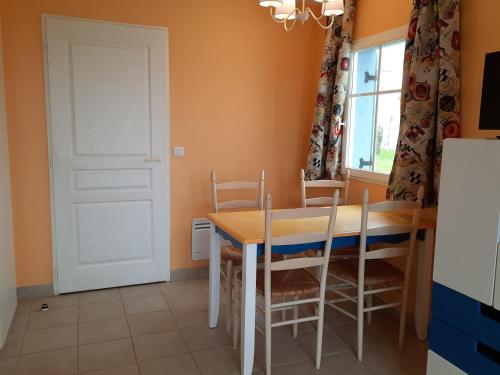 a dining room with a table and chairs and a door at Maison avec vue sur mer dans Résidence Marie Galante in Locmaria