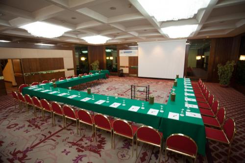 a conference room with green tables and red chairs at Etrusco Arezzo Hotel - Sure Hotel Collection by Best Western in Arezzo