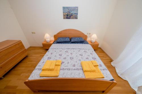A bed or beds in a room at Nikolina Rab Apartments