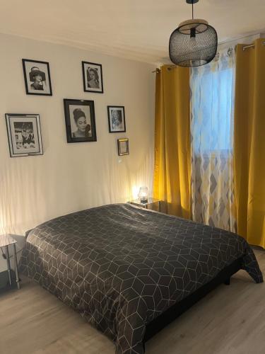 um quarto com uma cama e uma cortina amarela em le mendes em Évron