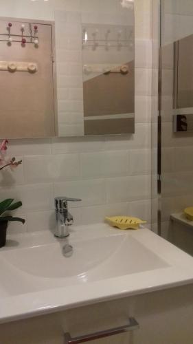 un lavabo blanc dans une salle de bain avec un miroir dans l'établissement Plein sud, à Saint-Mandrier-sur-Mer