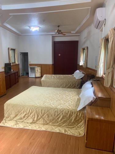 a hotel room with two beds and a tv at Xiaoye Liu Homestay in Guoxing