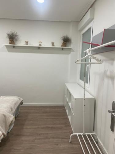 a bedroom with a bed and a dresser and shelves at Duquesa 32 in Logroño
