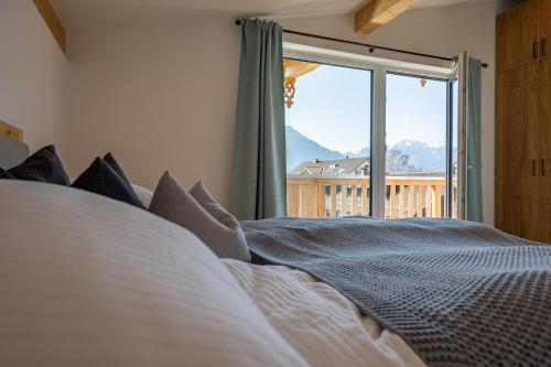 - une chambre avec un lit et une grande fenêtre dans l'établissement Haus Margreiter, à Nußdorf am Inn