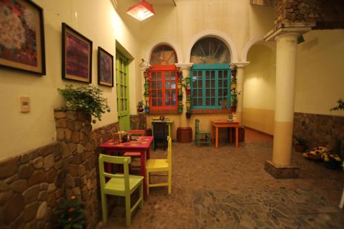 Hostel Cultural Pata y Perro في تاريخا: غرفة مع طاولة وكراسي في مبنى