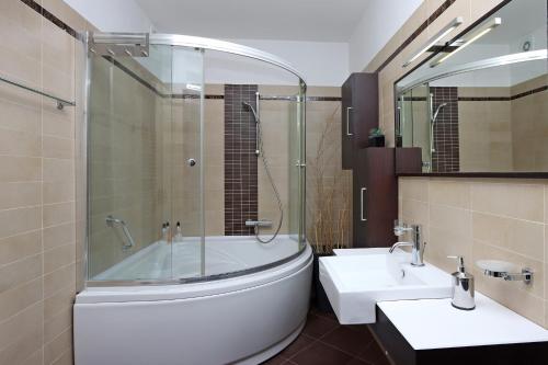 a bathroom with a tub and a sink at Starry Night - Smart TV, Extra big bed, big bathtub, private parking, sea view, WIFI, 2bedrooms in Volosko