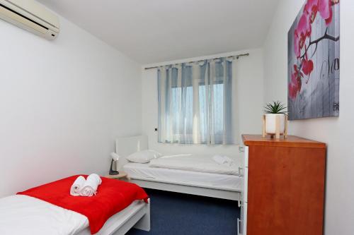 a bedroom with two beds and a dresser in it at Starry Night - Smart TV, Extra big bed, big bathtub, private parking, sea view, WIFI, 2bedrooms in Volosko