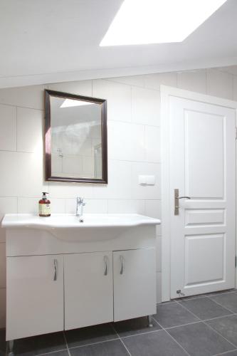 a white bathroom with a sink and a mirror at Bluberry Central Fethiye's apartment in Fethiye